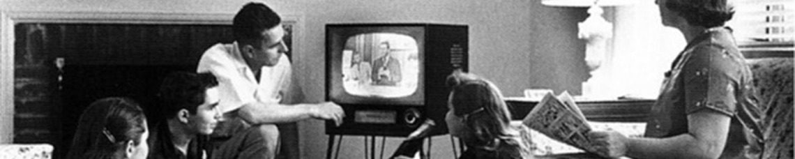 Vintage black and white photo of a family watching a television set