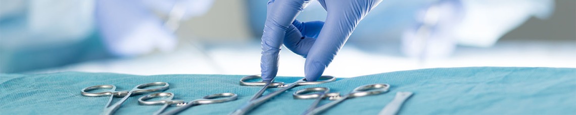 Hand with glove reaching for surgical instruments