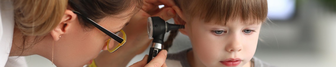 Nurse checking child patients ear