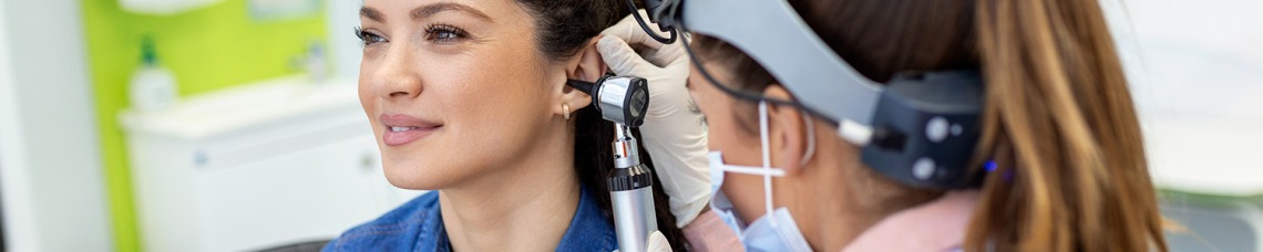 Nurse checking female patients ear