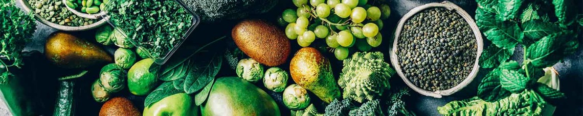 Green veggies and fruits on table