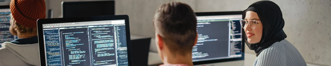Man and woman working on code on their laptops 
