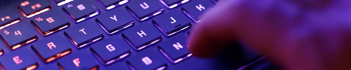 Hand typing on a purple keyboard